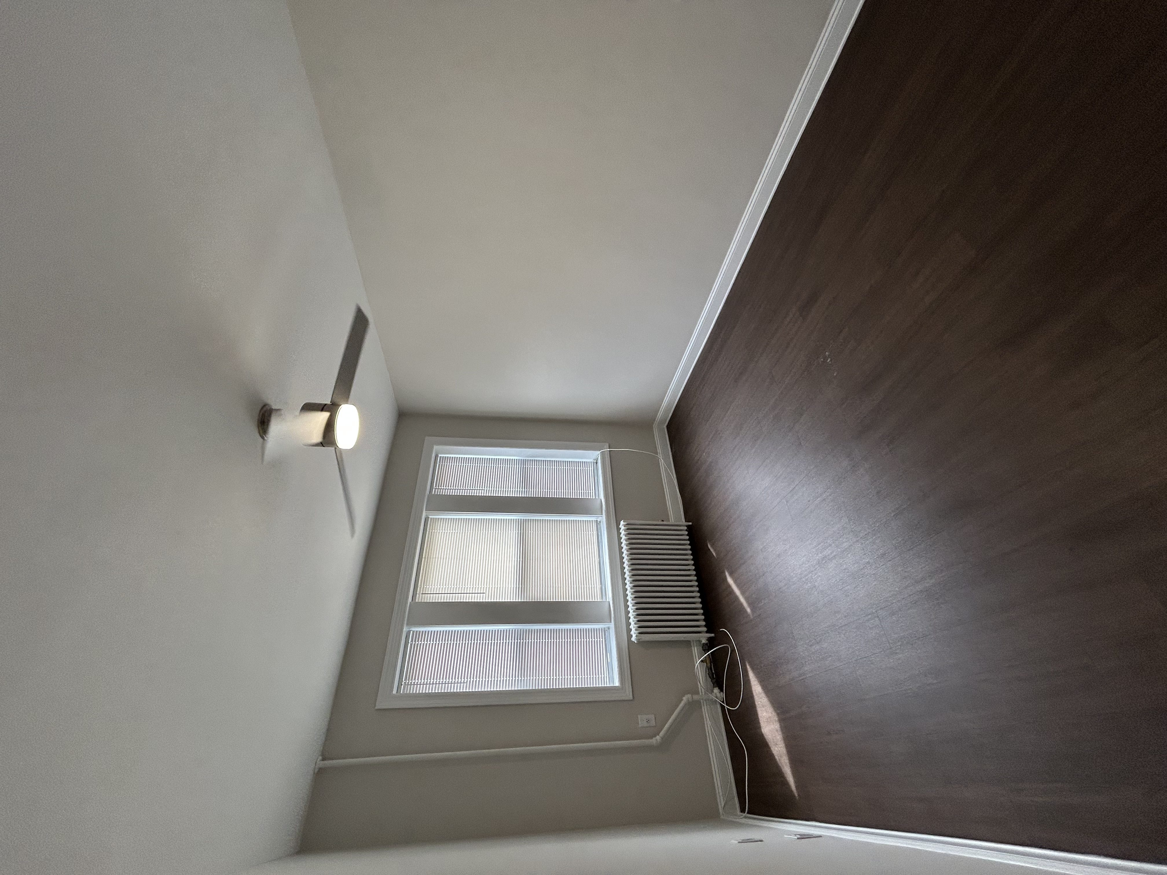 A small window with blinds is on a wall.